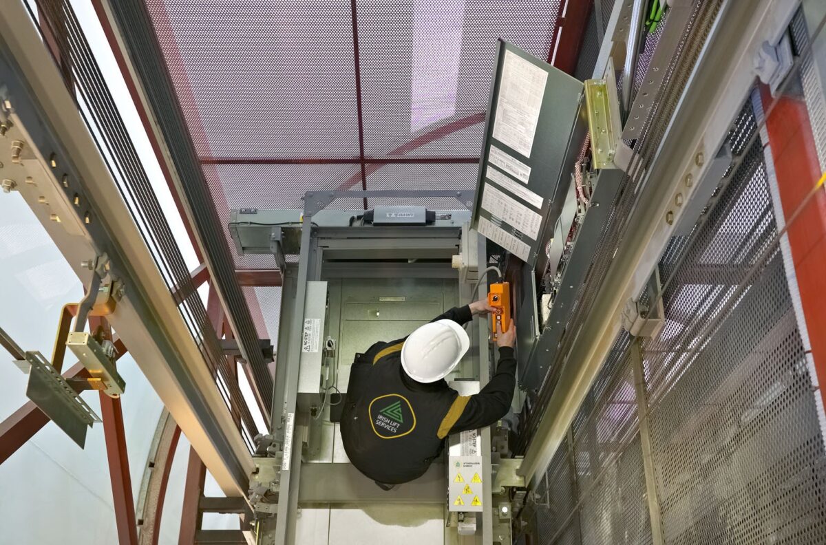 Irish Lift Services technician working at the top of an elevator.